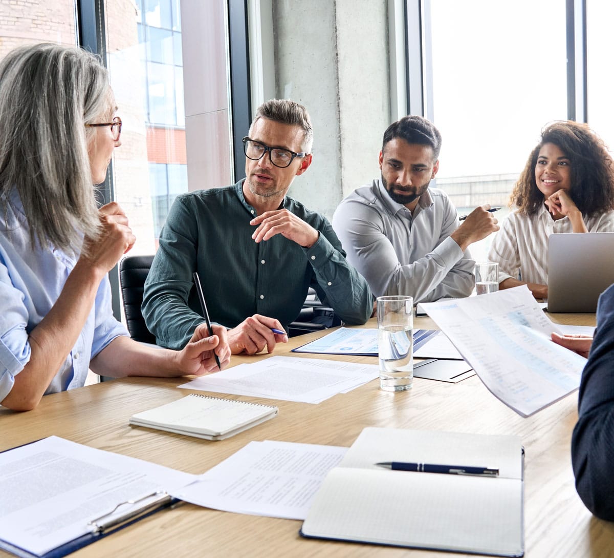 Team meeting with people talking and listening at a long table