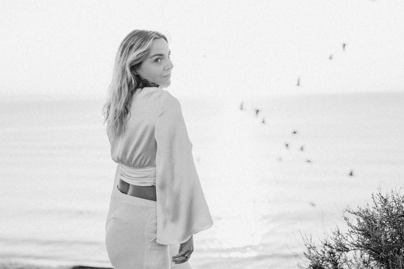 Valérie looking over her shoulder, birds in the sky behind her