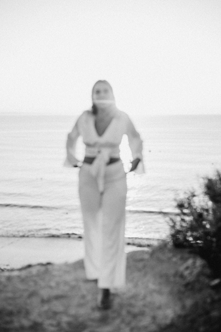 Val&eacute;rie walking towards the camera by the sea