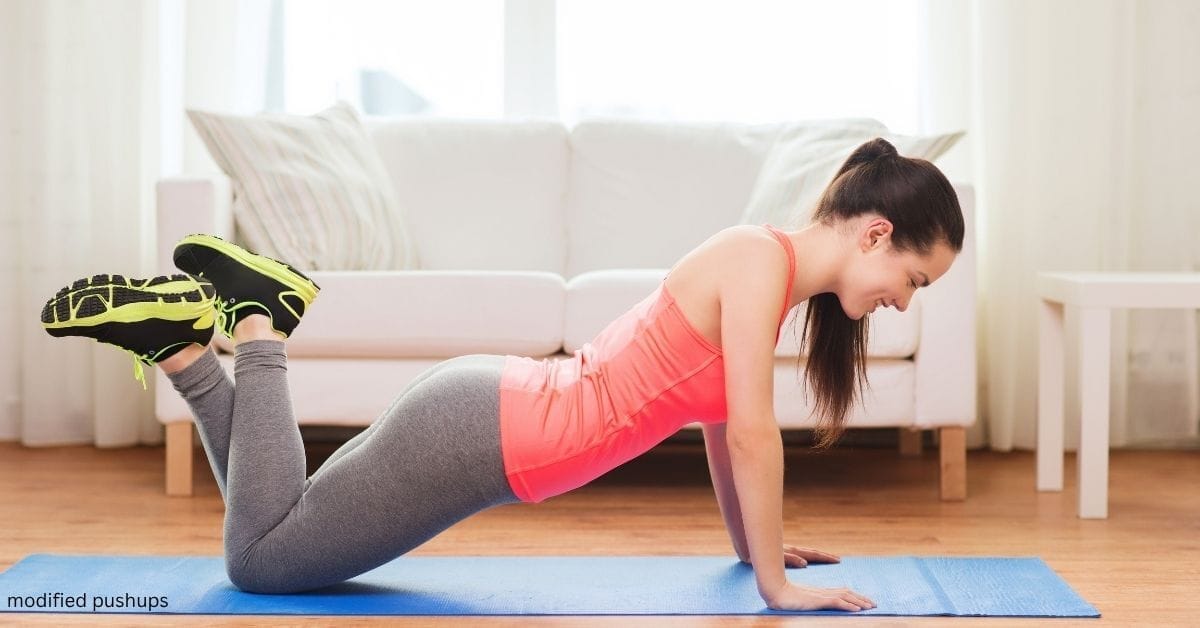 A woman doing modified pushups (pushups on her knees) at home