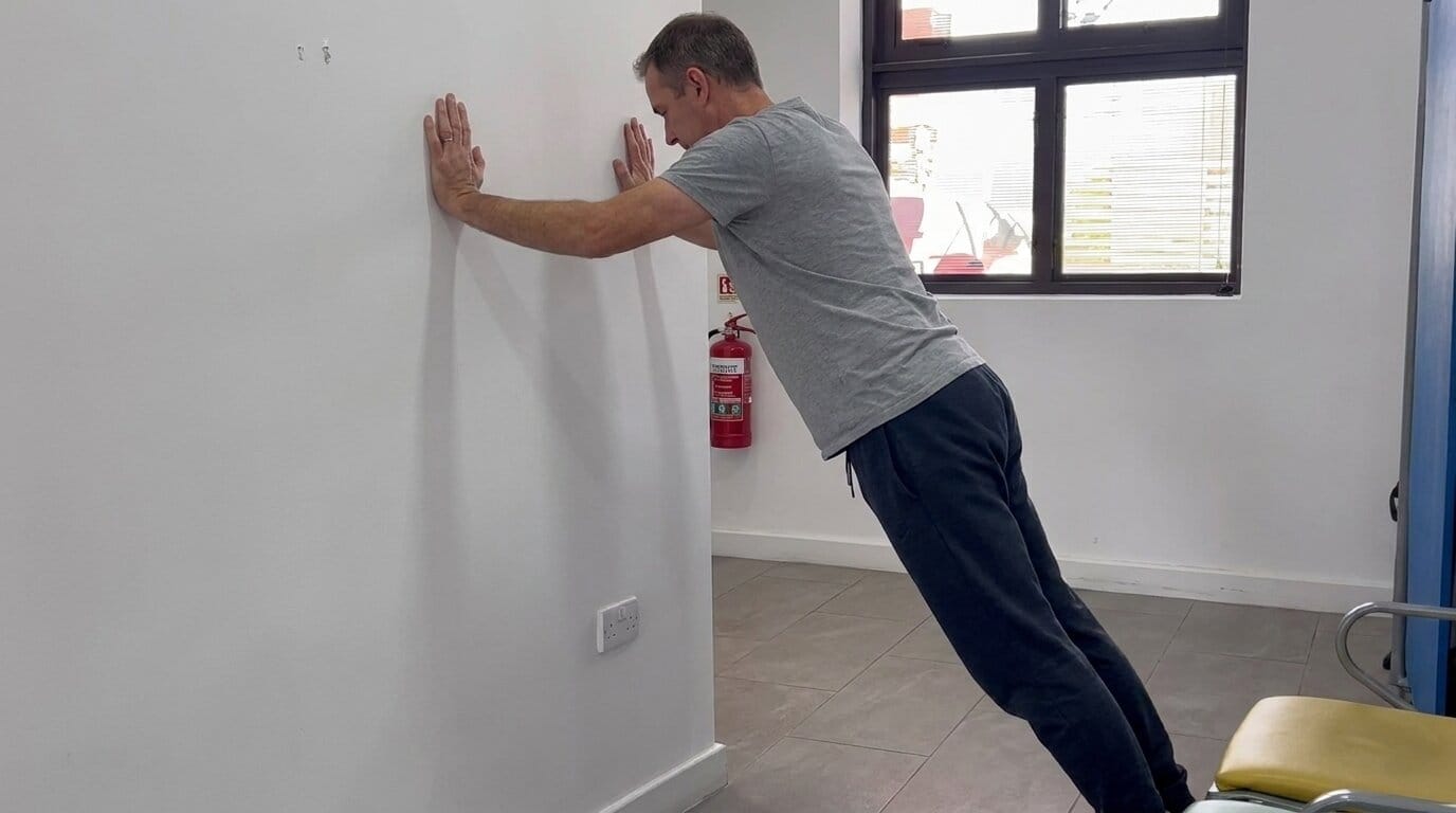 A man performing wall pushups
