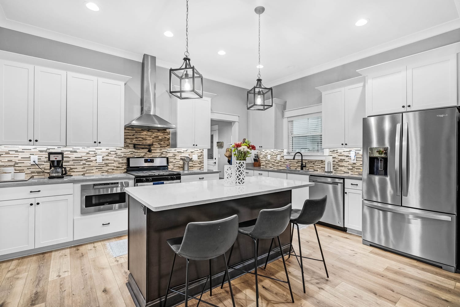 High-end kitchen photography showcasing granite countertops, island, and stainless steel appliances