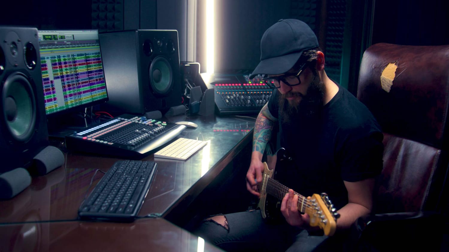 A musician recording guitar in a home studio with a DAW session open, representing the confidence and creative freedom beginners gain after learning MIDI basics.