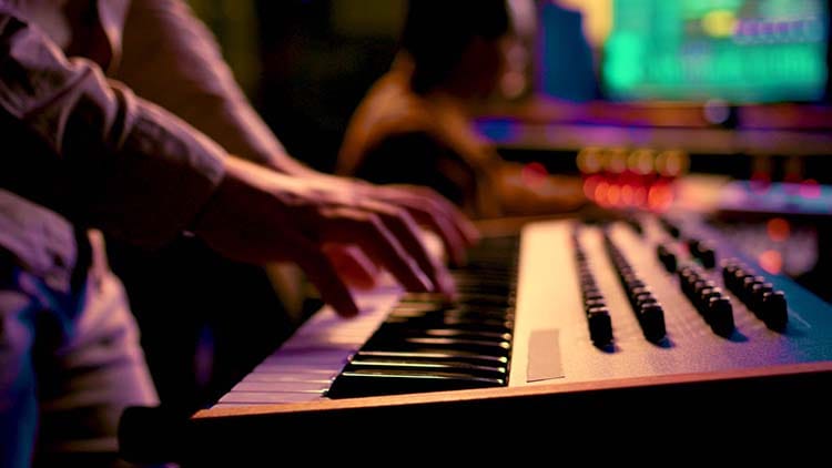 A musician playing a small keyboard in a colorful studio environment, symbolizing beginners taking their first steps into creating music with MIDI.
