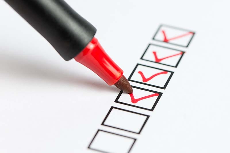 An image of a pen checking a box in a checklist.