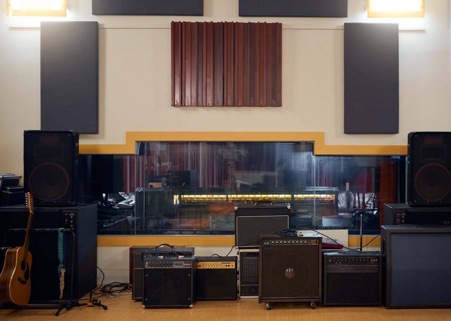 Recording studio control room featuring acoustic wall treatment absorption panels above studio monitors