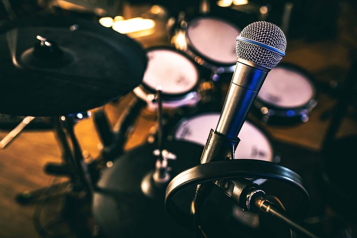 Dynamic microphone positioned in front of an electronic drum kit with mesh heads used as a MIDI controller