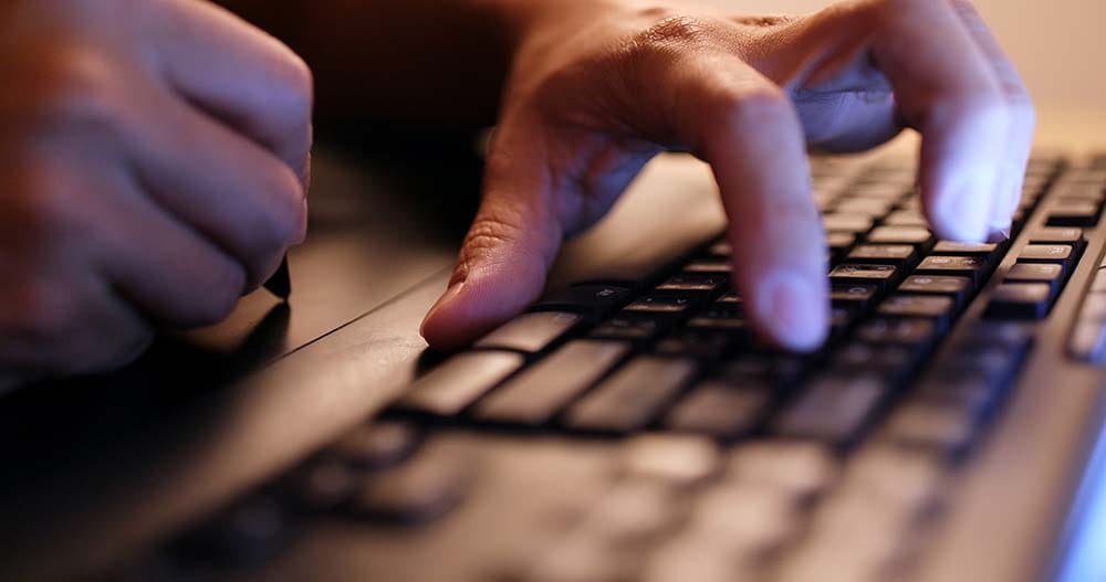 Close-up of hands using computer keyboard shortcuts to speed up DAW music production workflow