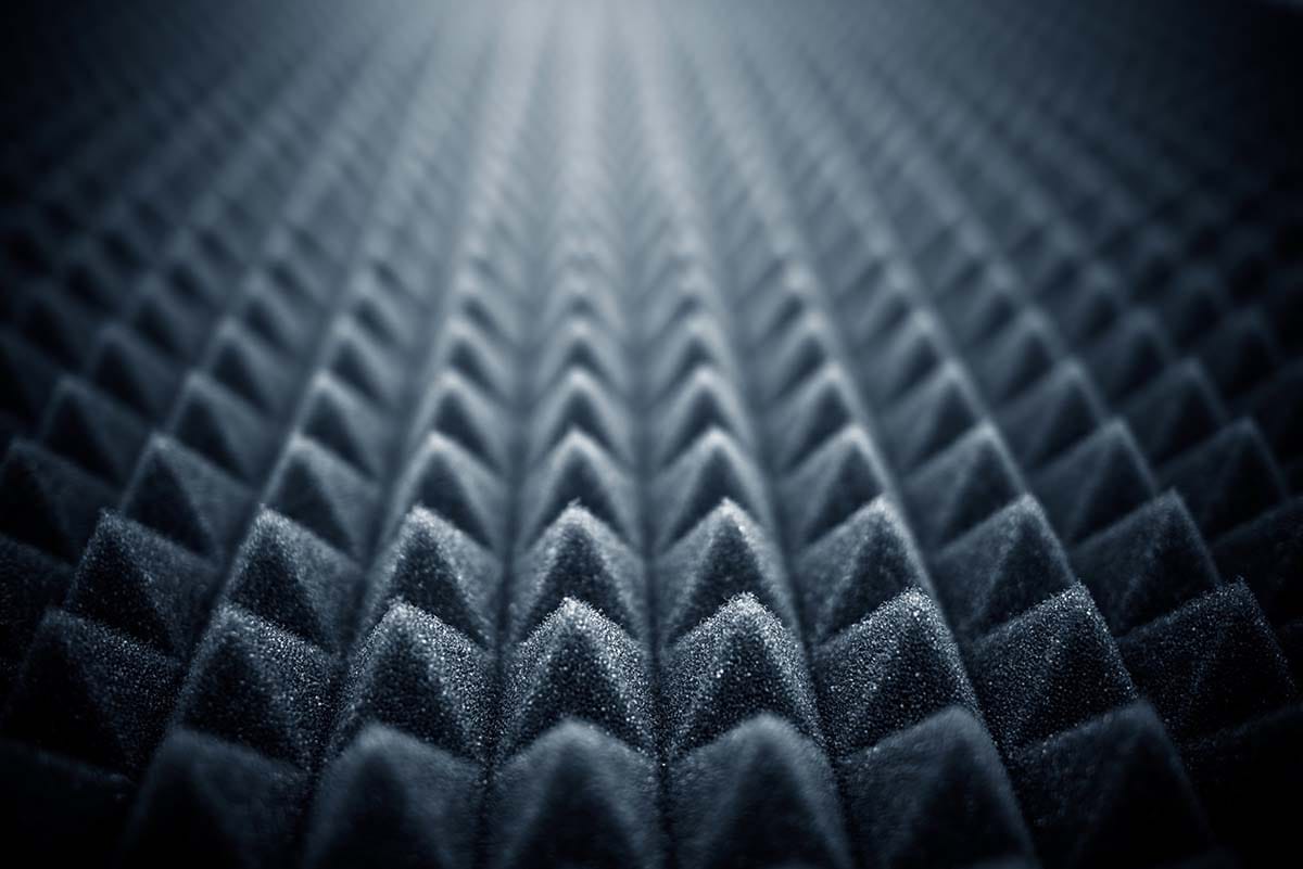 Close-up view of dark grey wedge acoustic foam panels used for high-frequency sound absorption