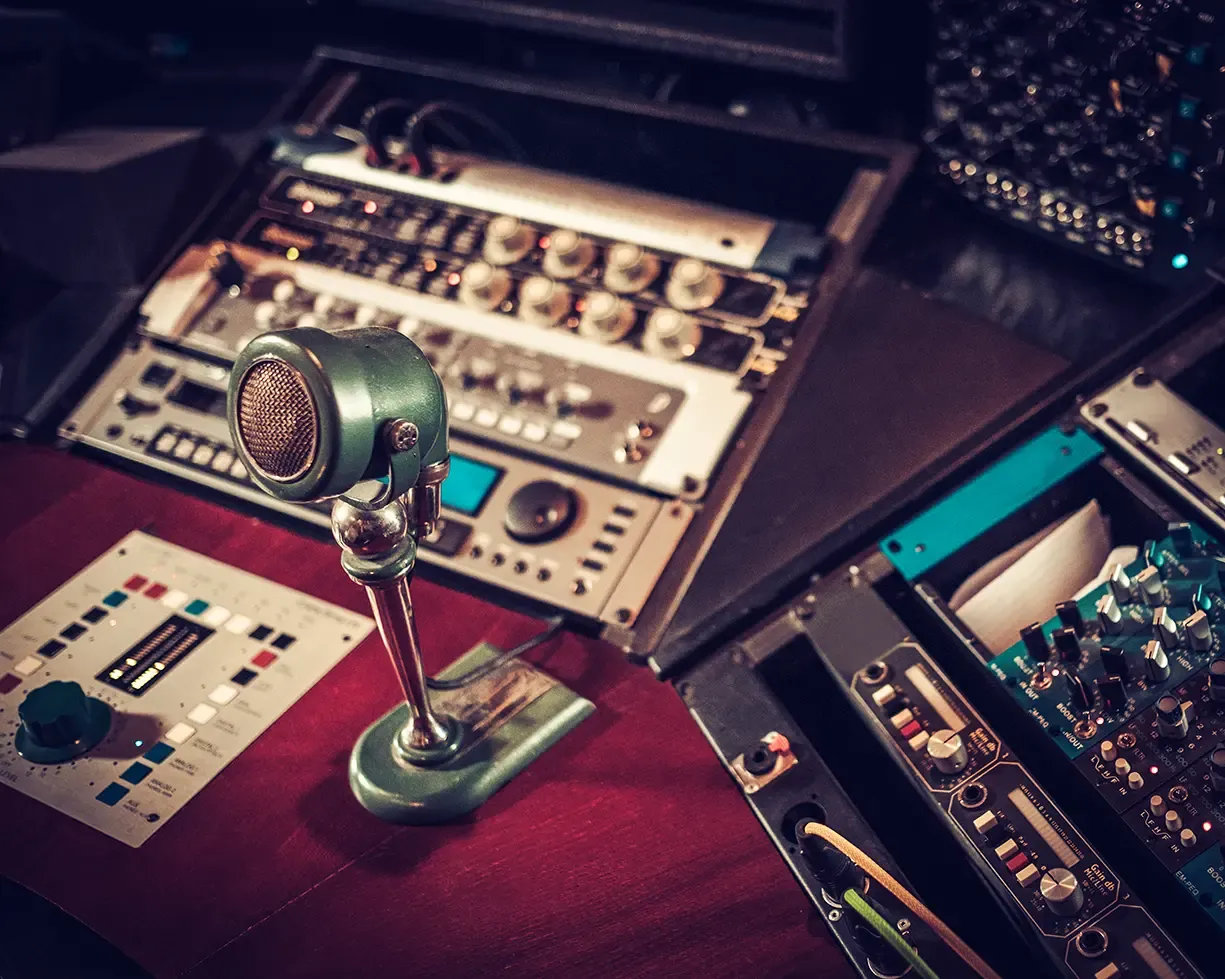 Vintage studio desk setup with desktop microphone and analog outboard gear racks