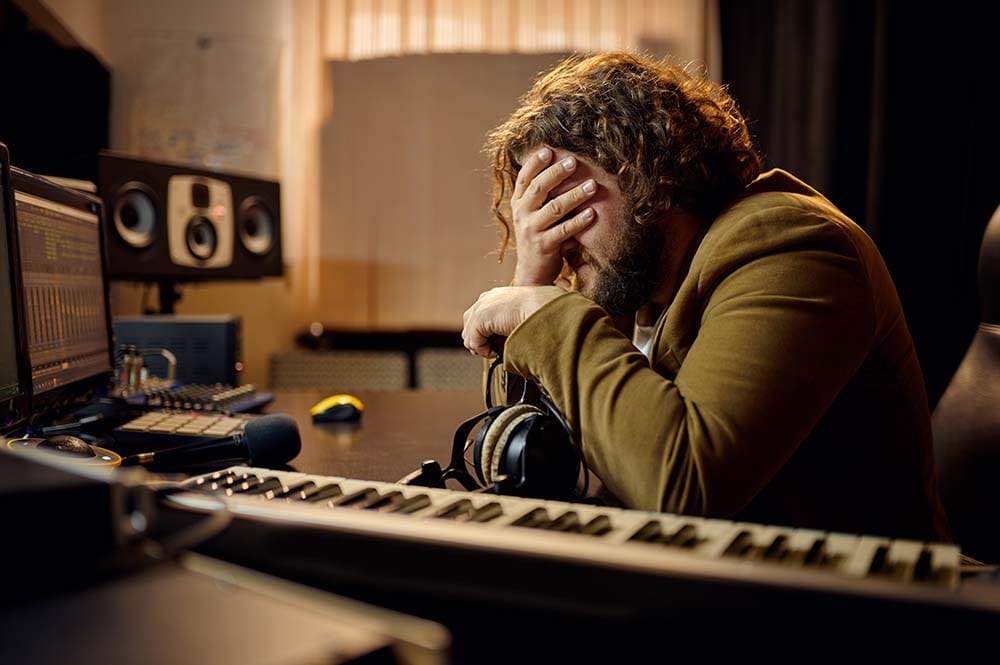 A frustrated music producer stressed out because of working on too large of a project too early.