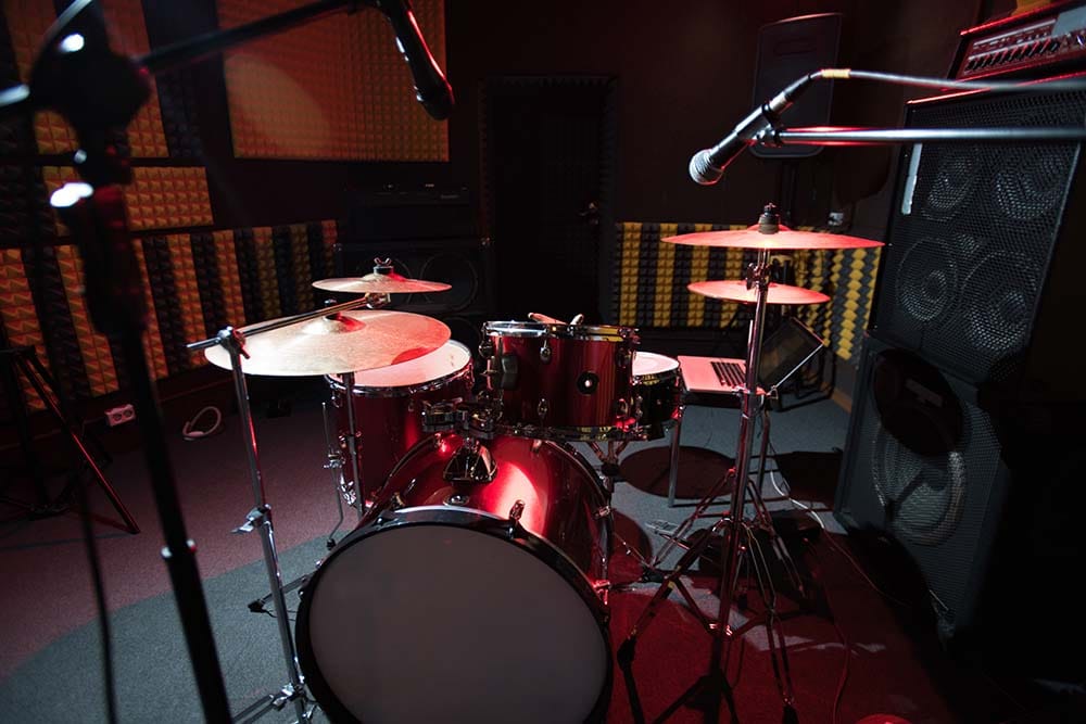 A drum set in a recording studio with microphones in place.