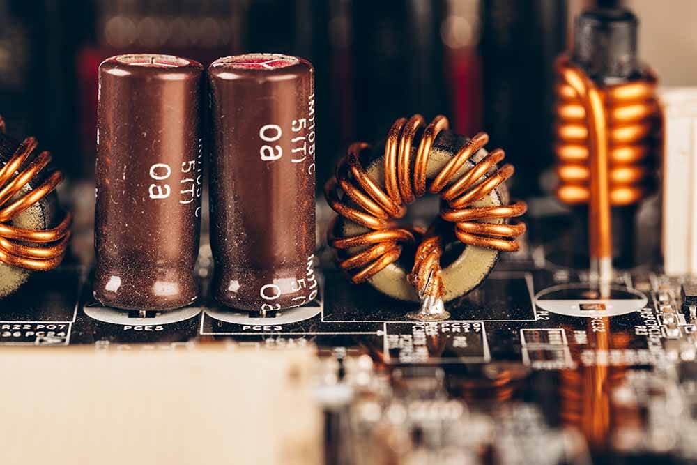 Electronic components on a circuit board, representing capacitors and inductors inside an analog EQ.
