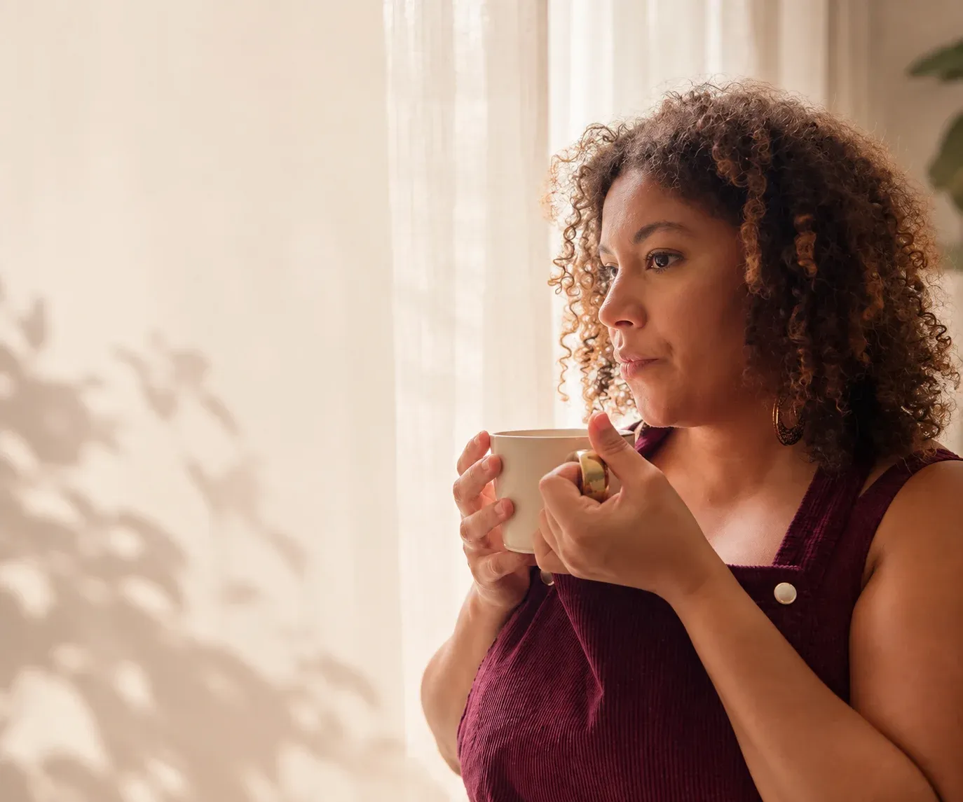 Coralie prend une pause, une tasse entre les mains
