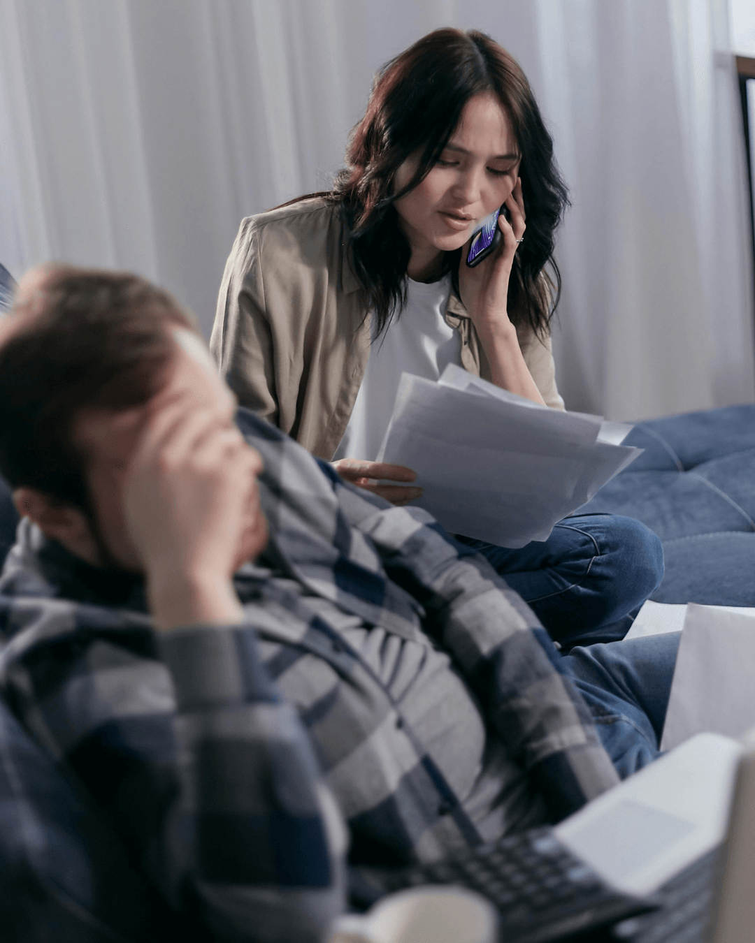 Stressed adult daughter on phone while elderly mother holds credit card - elder scam recovery