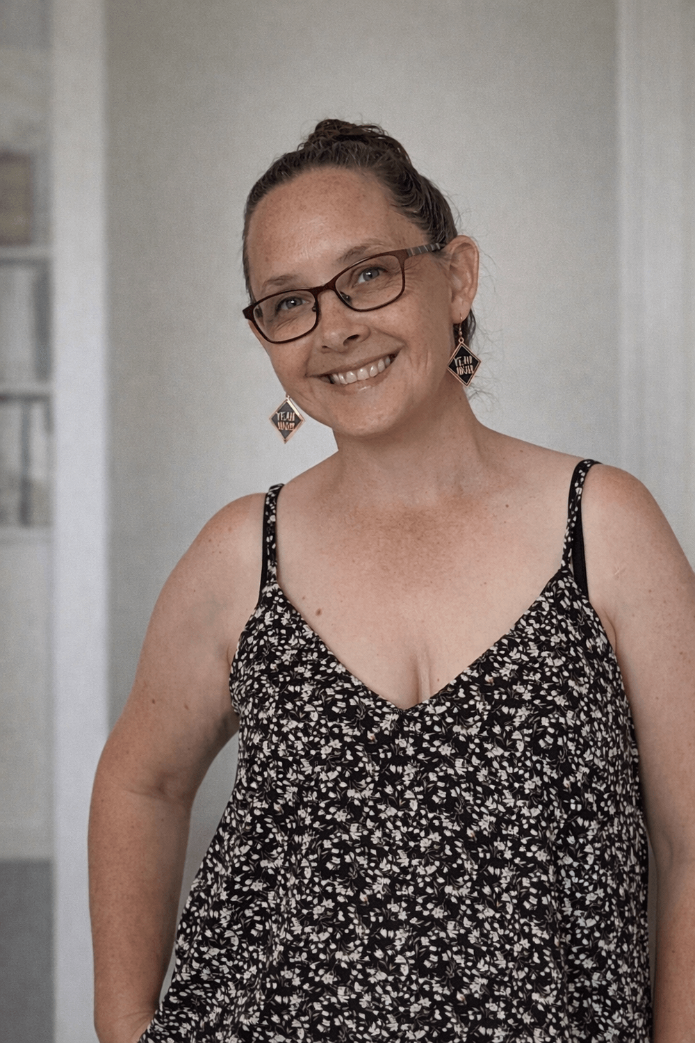 Donna from Minimum Nutrition wearing a black shirt, tilting head and smiling.