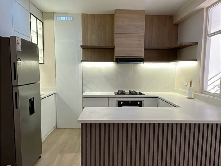 Remodelación de cocina moderna con muebles de madera y acabados minimalistas en Perú