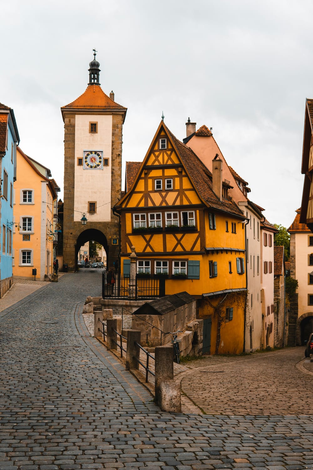 alt="Half-timbered medieval buildings lining a cobblestone lane in the old town, Rothenburg ob der Tauber, Germany"