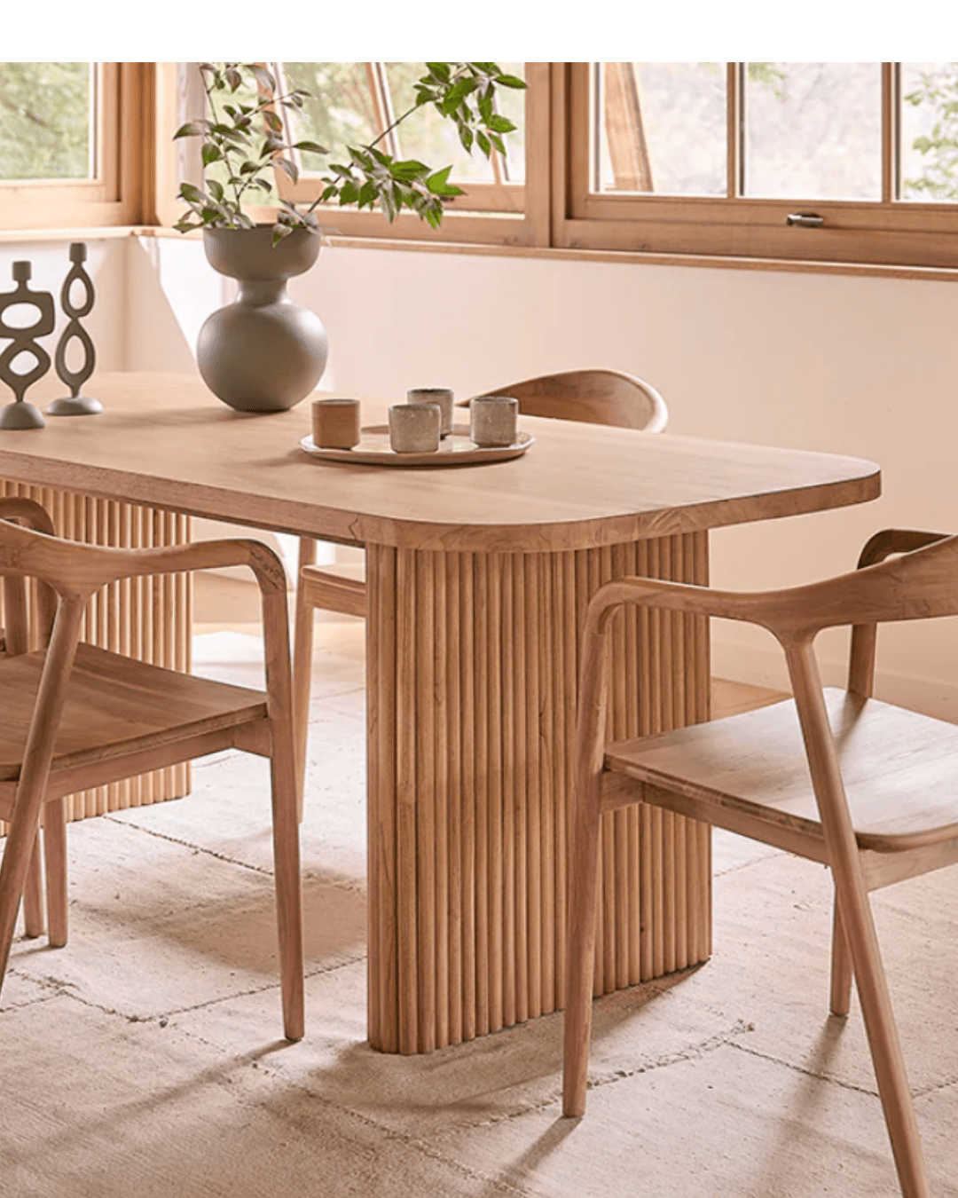 Table en bois brut et chaises tressées pour une salle à manger artisanale au design ethnique.
