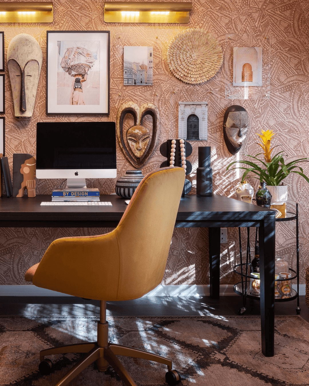 Bureau Afrohemian inspirant avec bureau en bois massif et décorations murales en fibres naturelles.