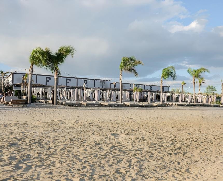 restaurant de plage Effet Mer La Grande Motte / rangée de transats et palmiers en bord de mer / paillote Hérault