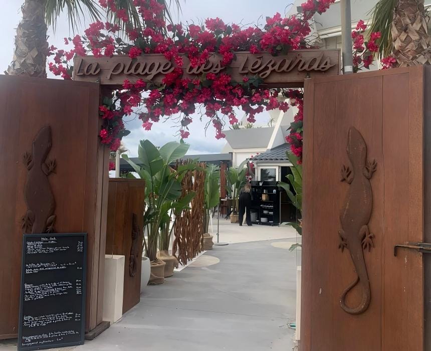 entrée bois sculpté La Plage des Lézards Palavas-les-Flots / portail lézards et arche fleurie bougainvillier / restaurant de plage Hérault