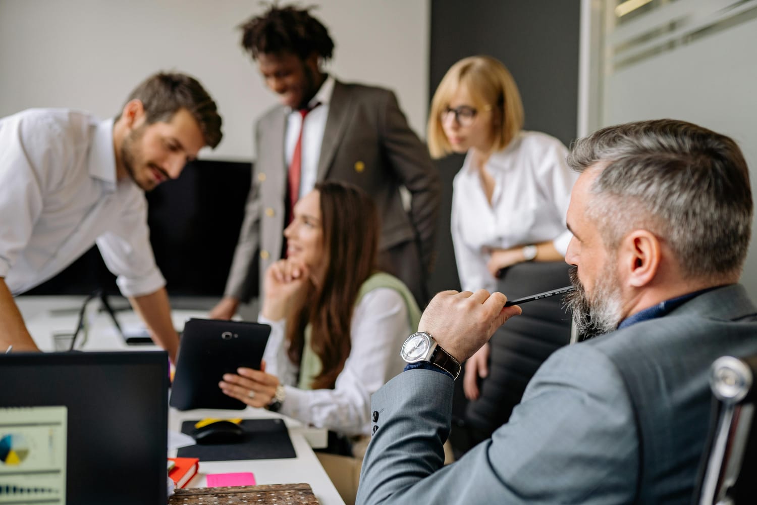 A group of professionals sitting around a conference table talking. 