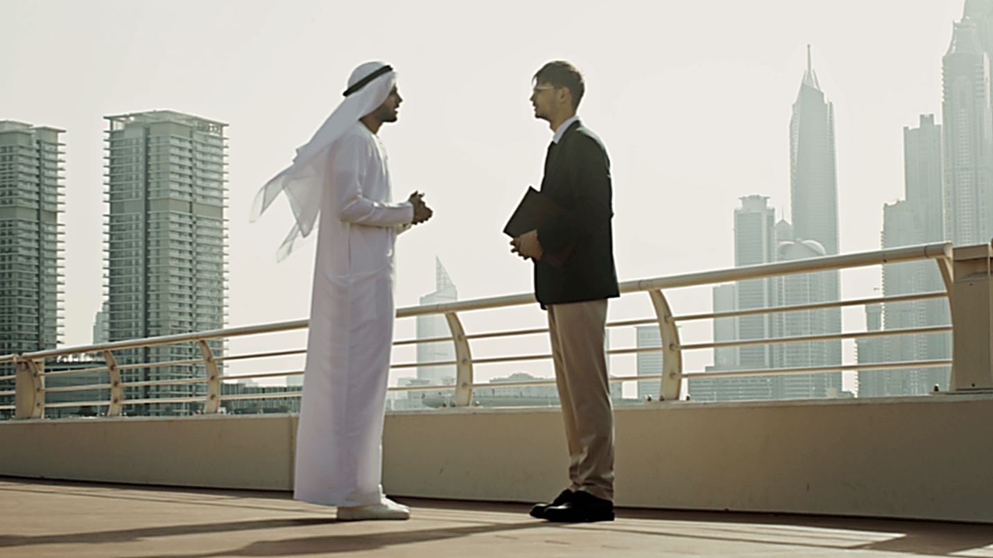 Professionals meeting on a terrace overlooking a Gulf city skyline