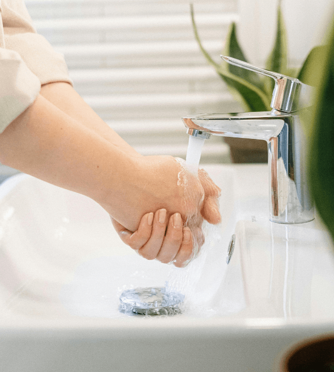 woman washing her hand in the faucet