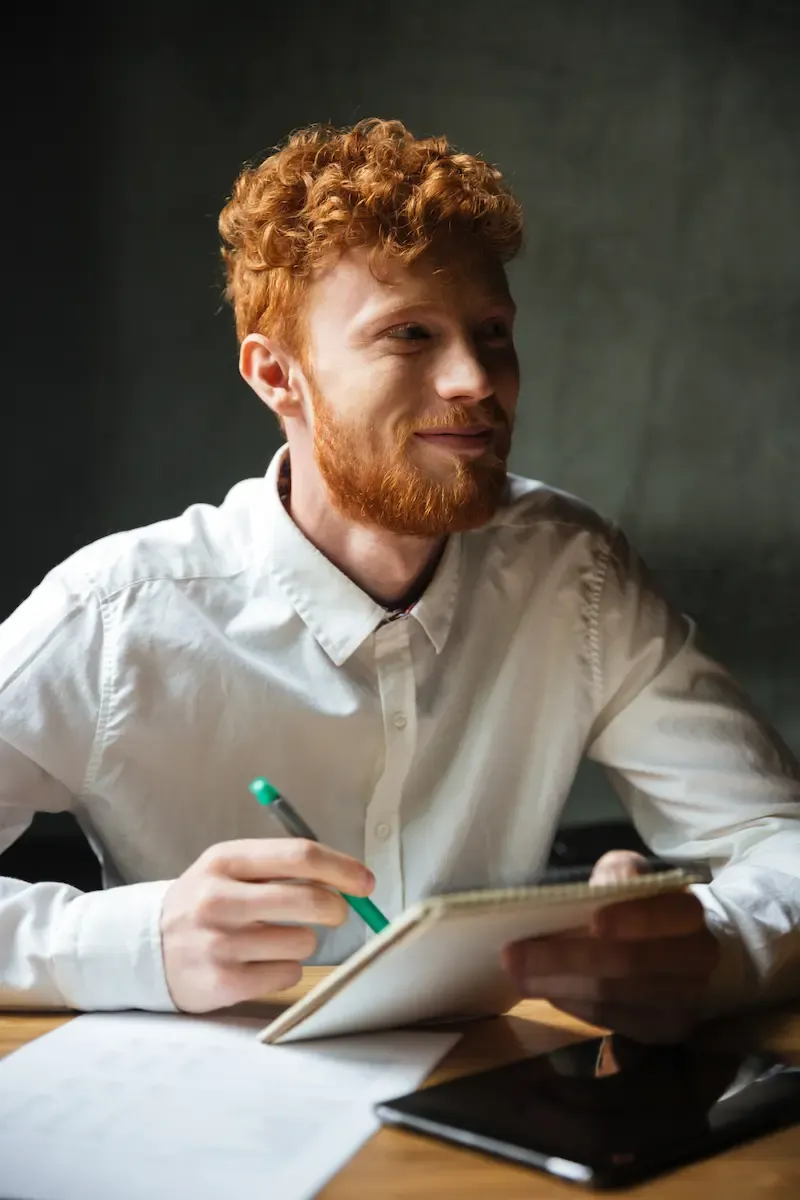 startup founder writing investor pitch Q&A preparation notes at desk
