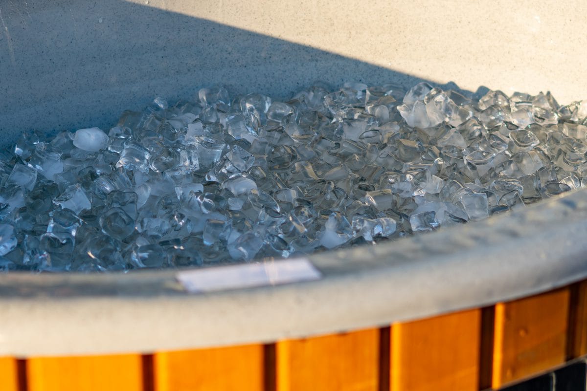 A wooden tub filled with ice outdoors at sunset