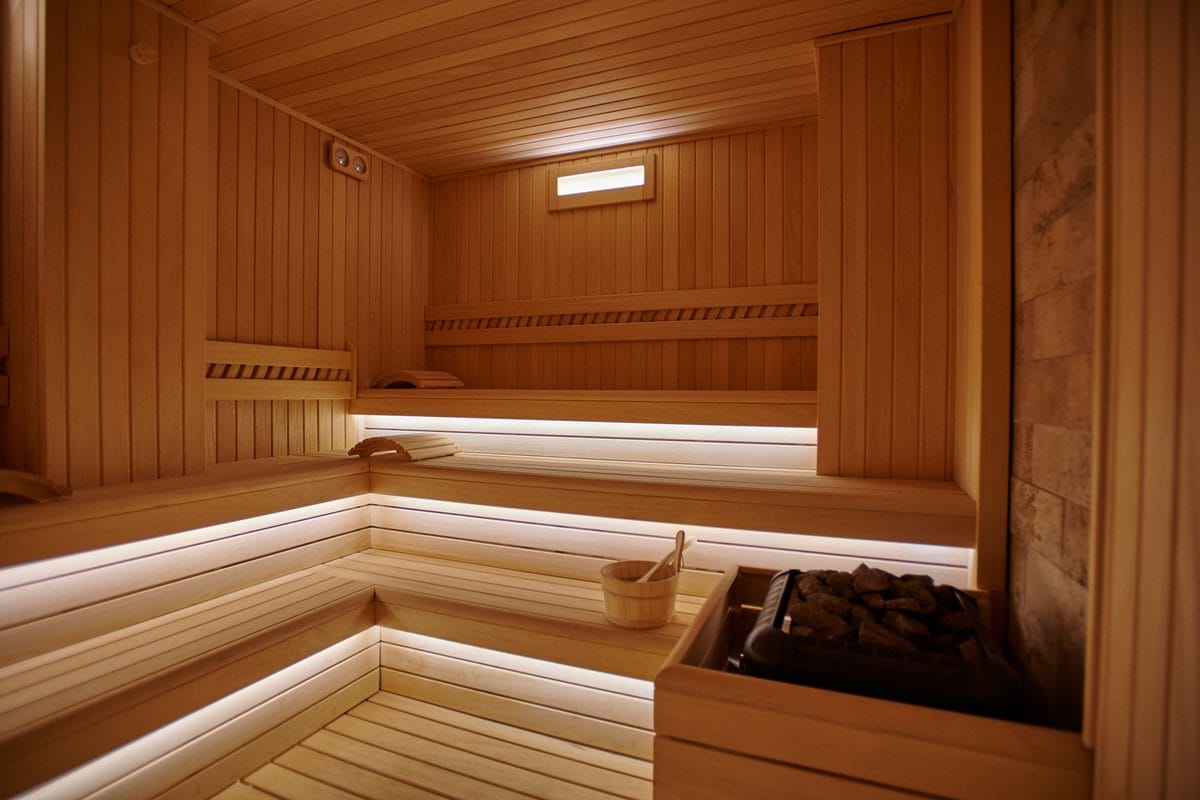 A wooden sauna interior with a heater and stones