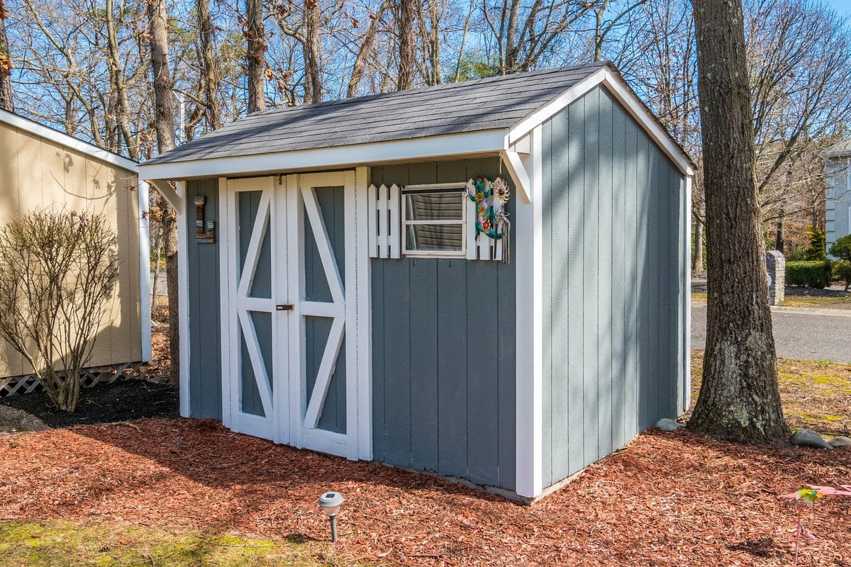 A small gray backyard storage shed