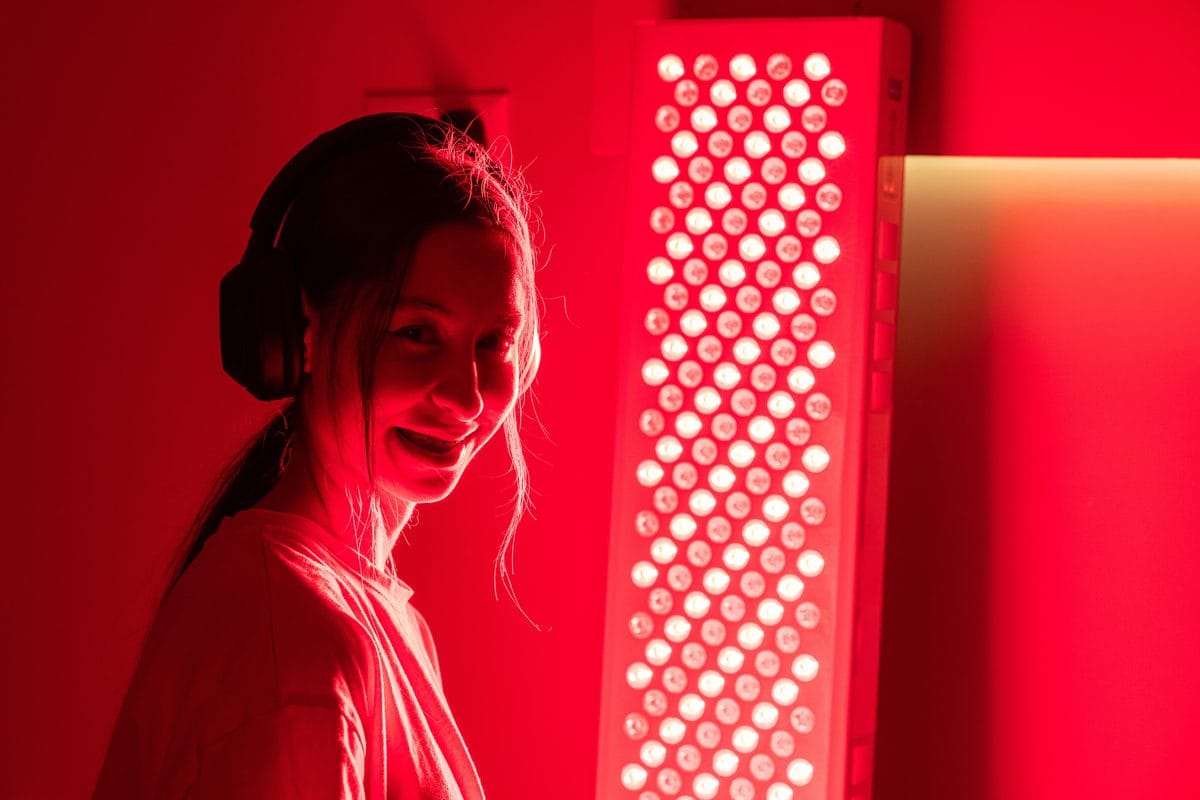 A woman sitting beside a tall red light panel