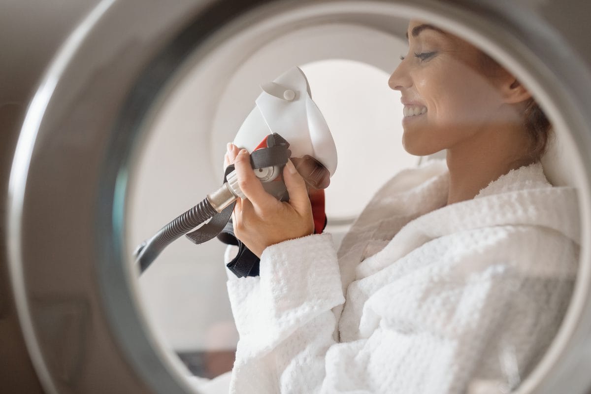 A woman inside a hyperbaric chamber seen through its window