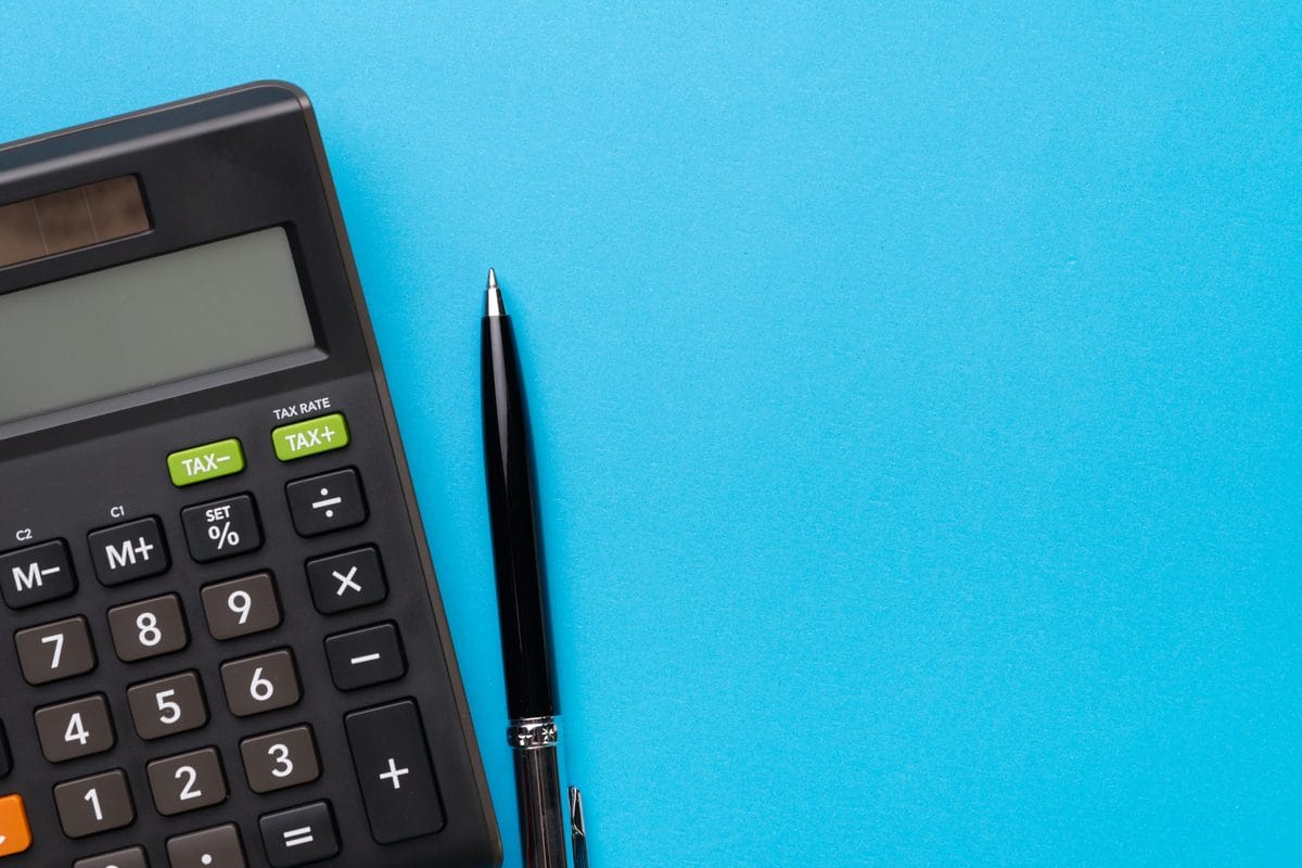 A calculator and pen on a blue background