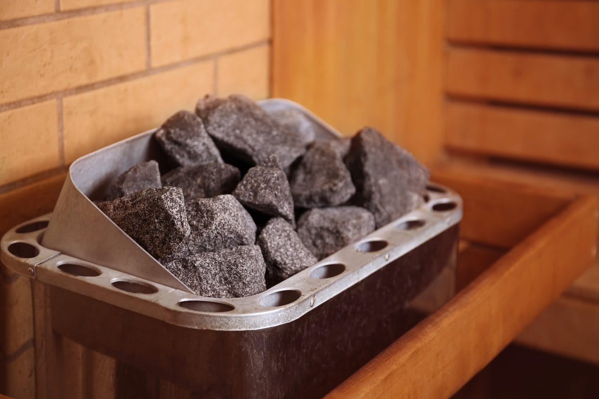 Sauna stones in an electric heater inside a wooden sauna