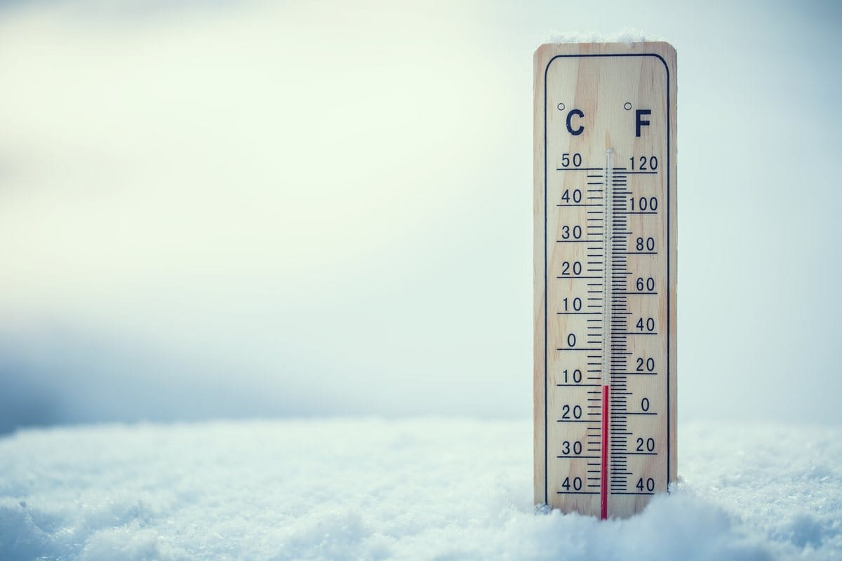 A thermometer standing in snow, reading below freezing