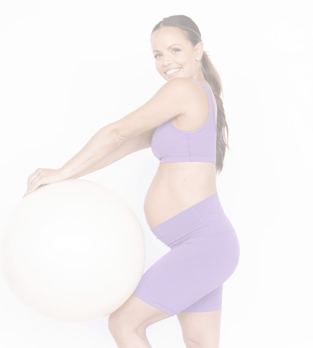 Femme enceinte souriante avec un ballon d'exercice
