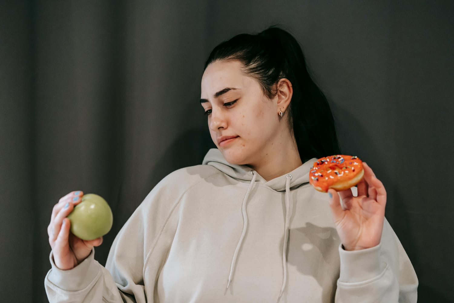 the woman decides whether to eat an apple or a doughnut