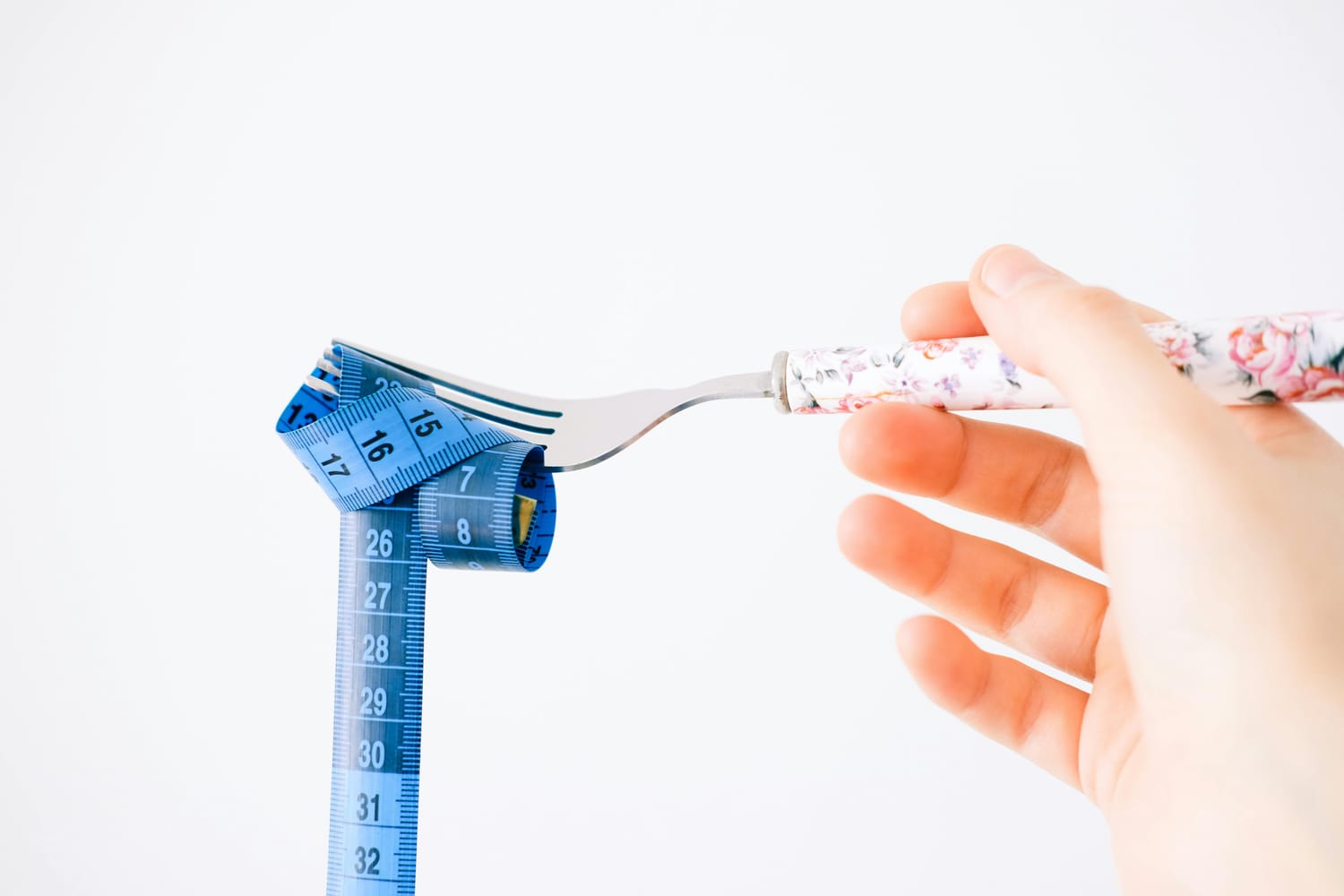 A fork with a rolled-up tape measure represents a calorie deficit.
