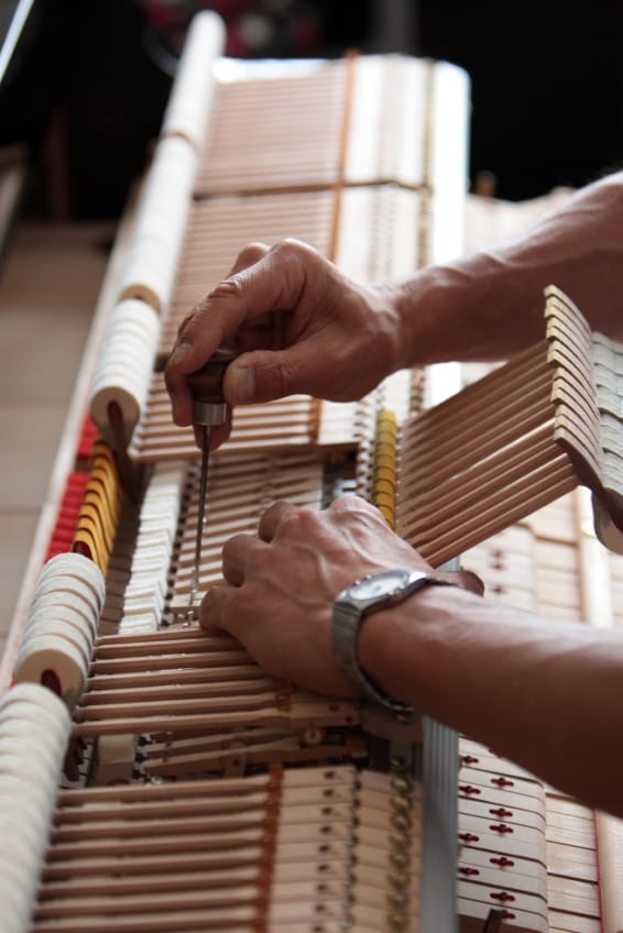 Piano technician regulating action