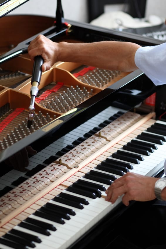 Piano tuner tuning a grand piano