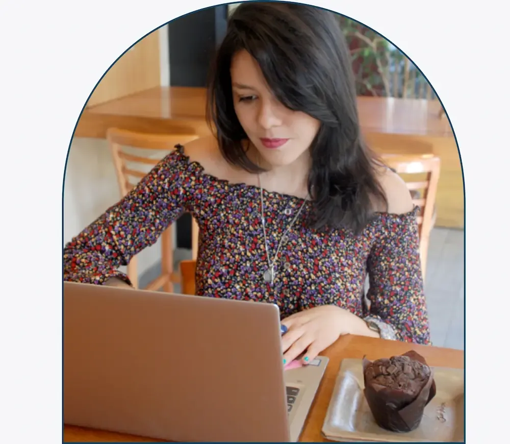 Samantha Mesones escribiendo en su laptop sobre un escritorio de madera