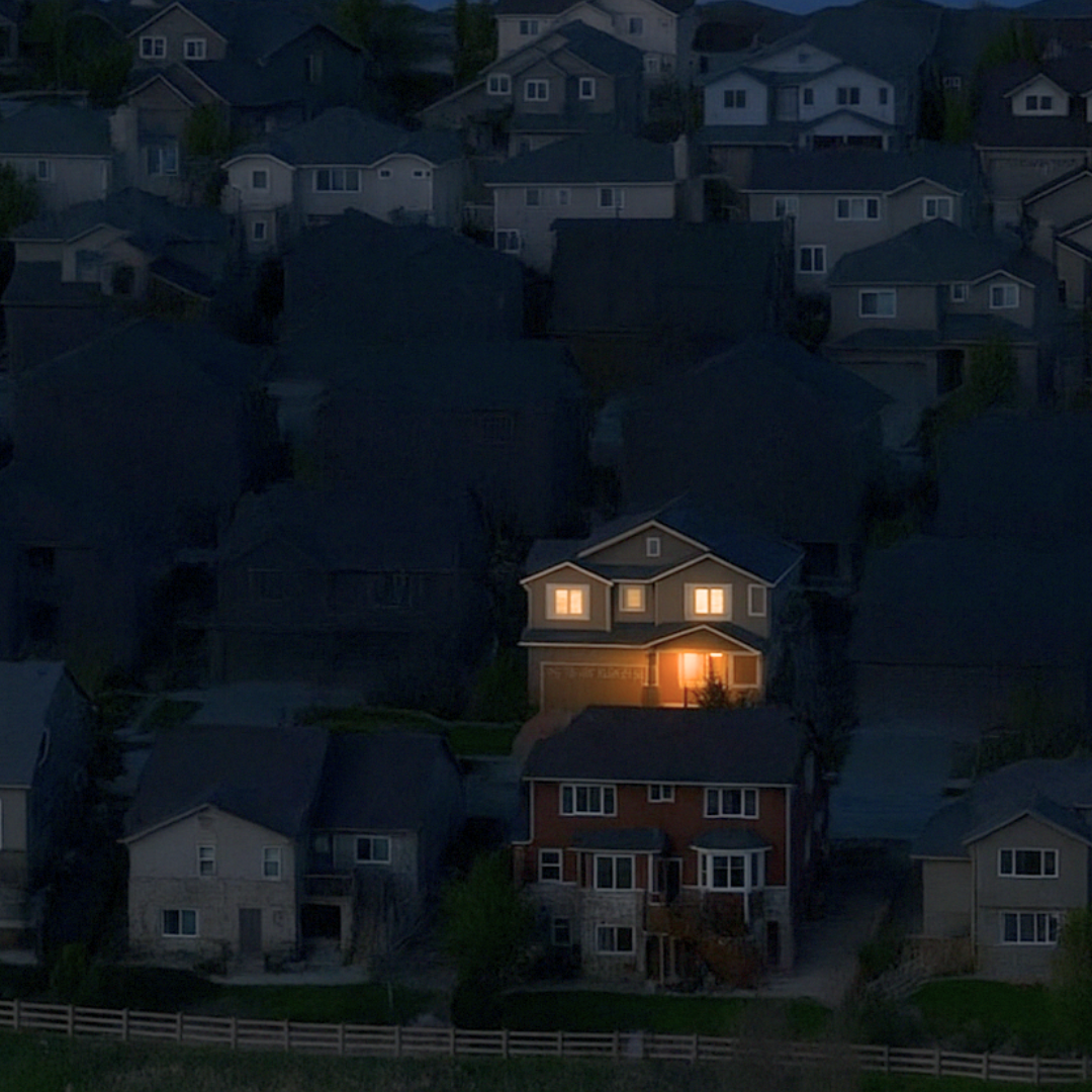 Une seule maison éclairée dans un quartier plongé dans le noir