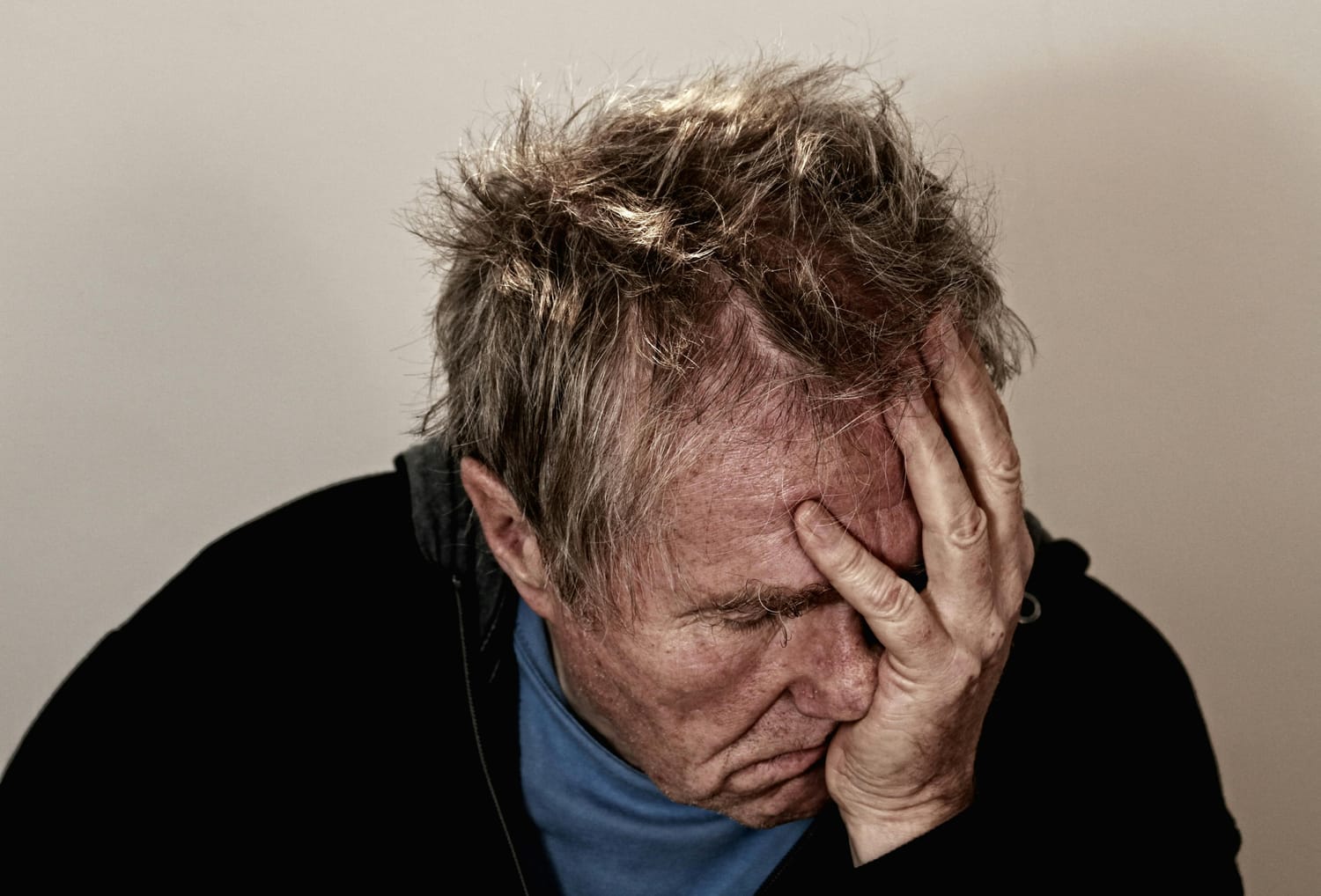 Older man holding his head