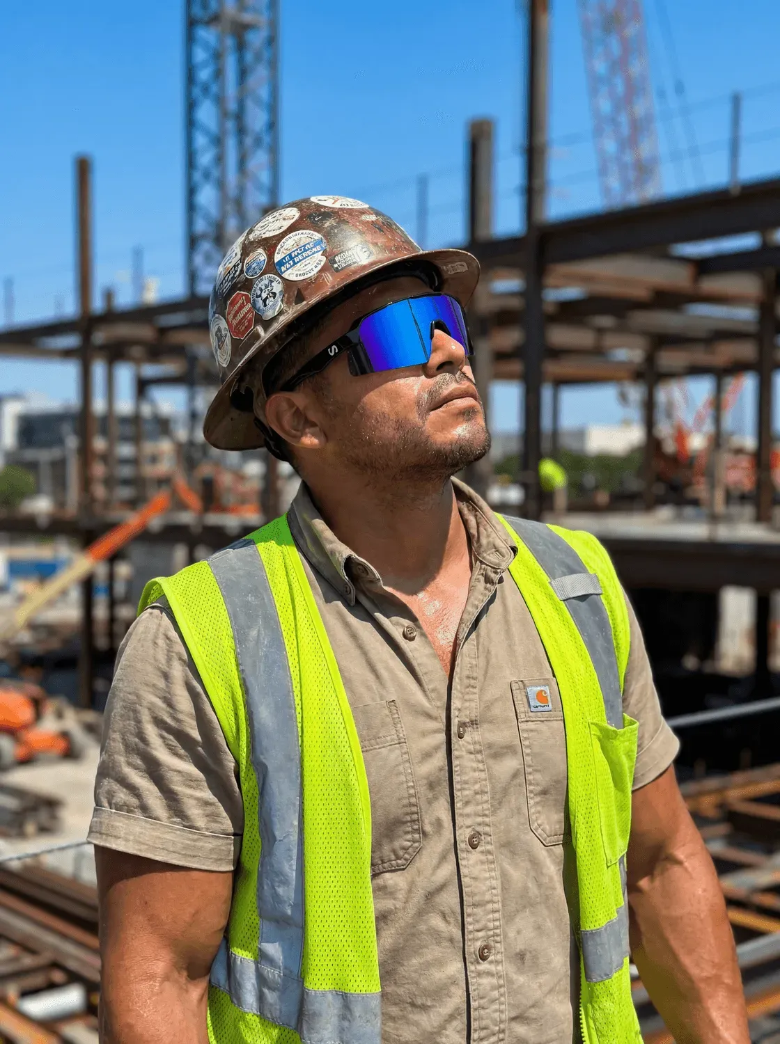 Man on steel construction looking up wearing Rangers safety glasses