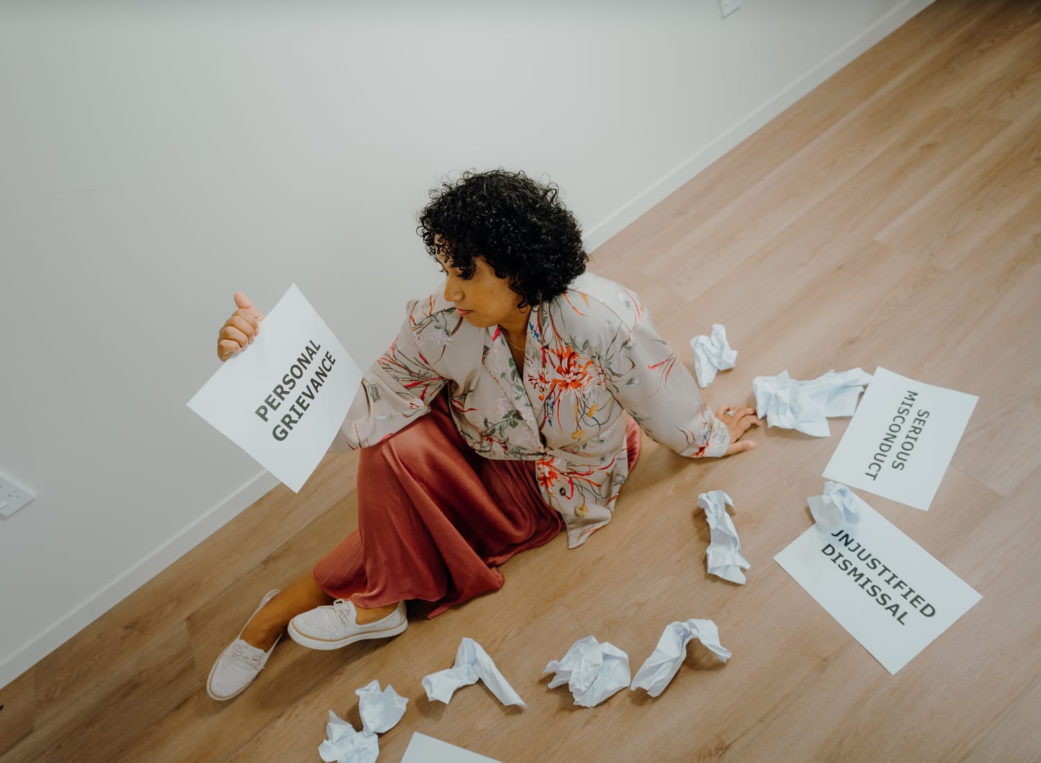 Sanam Permal with Personal Grievance paper among employment law documents