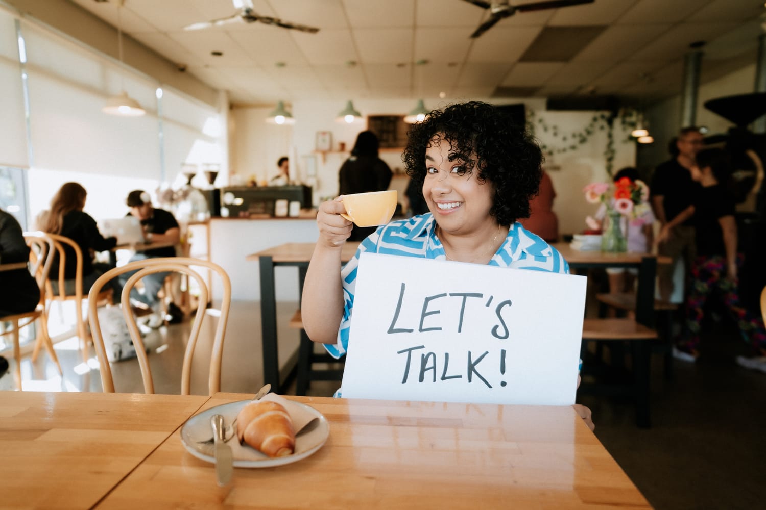 Sanam Permal, Law Lenz founder, holding a Let's Talk sign