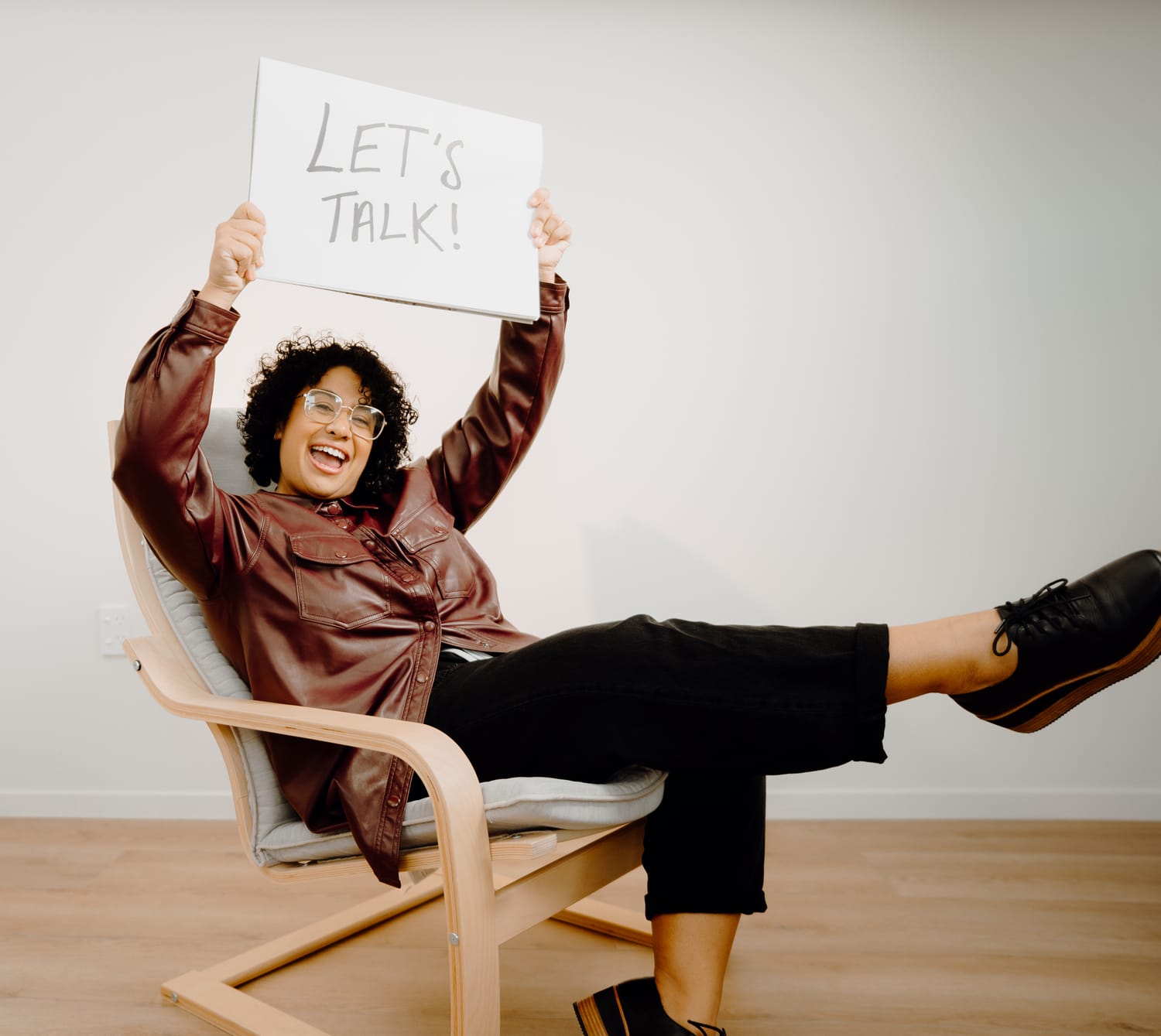 Sanam Permal, Law Lenz founder, holding a Let's Talk sign above her head